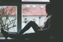 illustratie: fata stă în geam odihnind picioarele lungi